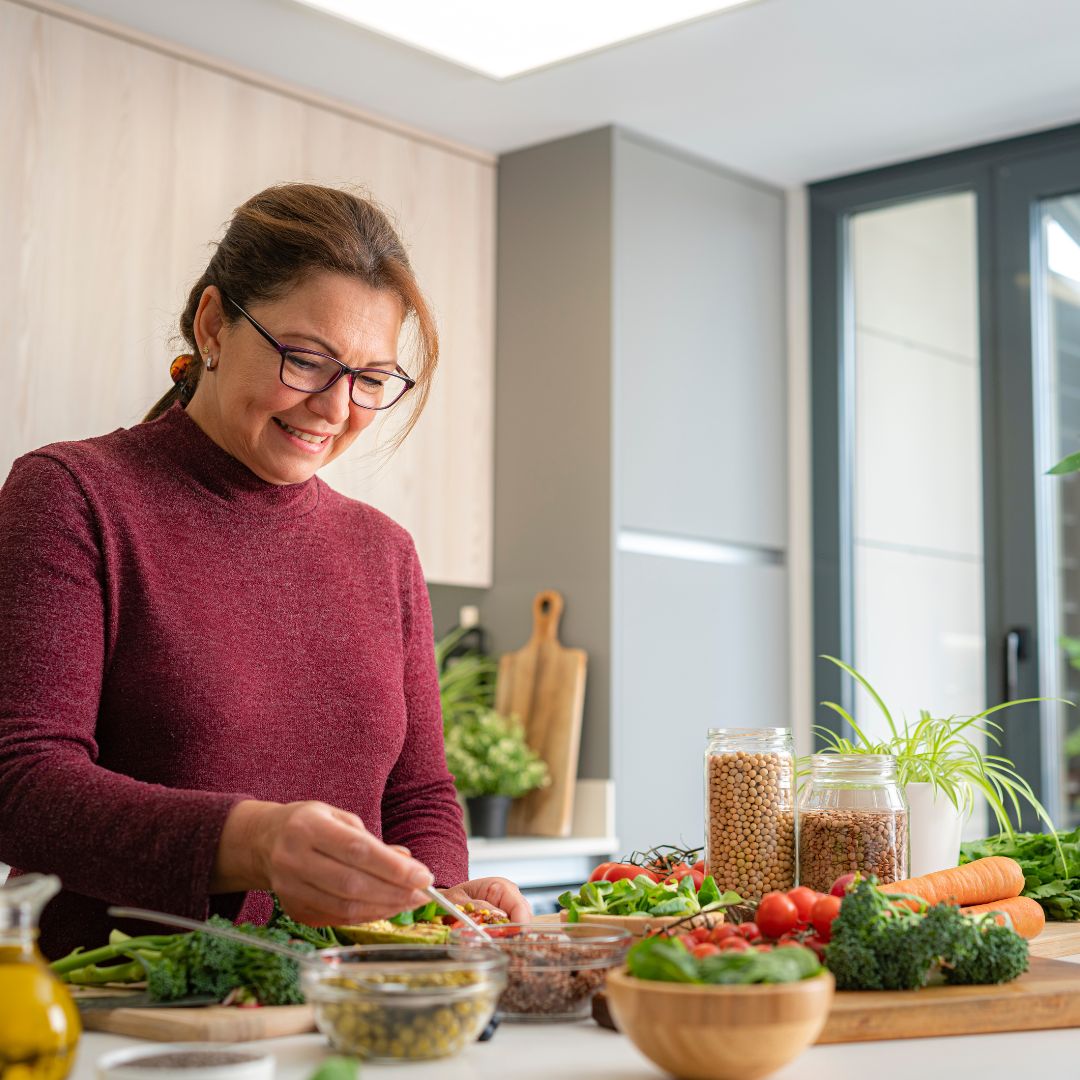 Woman in her 40s preparing a Mediterranean-style meal to support hormone balance during perimenopause